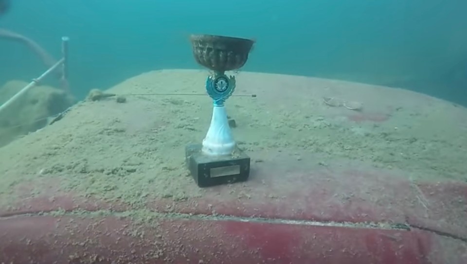 a trophy sits on the bottom of a boat in the water