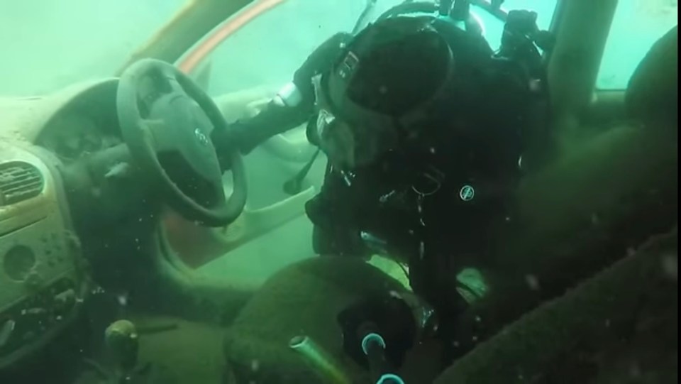 a scuba diver is looking at the inside of a car