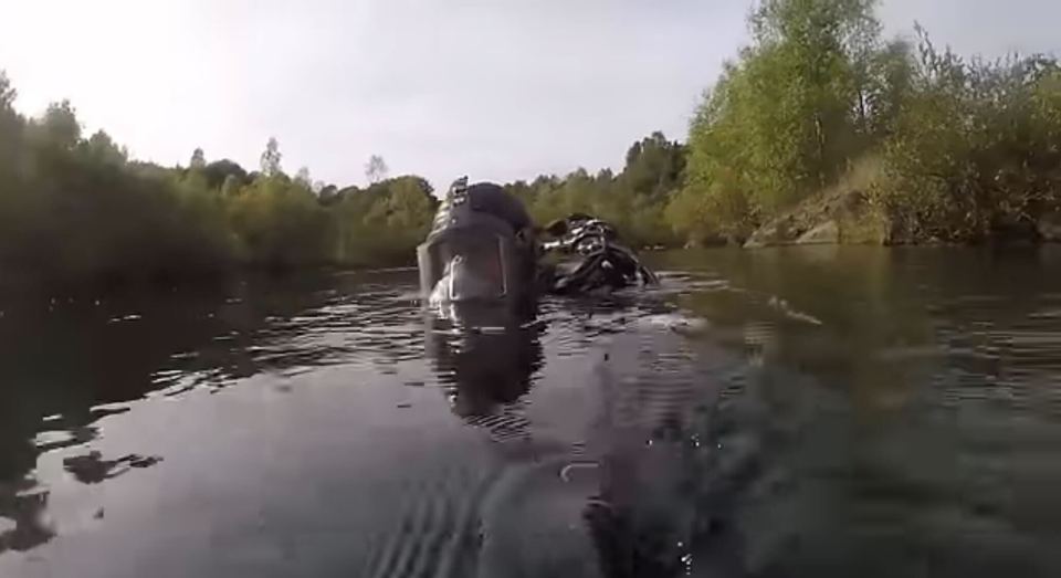 a person is swimming in a lake with trees in the background