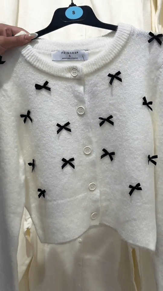 a white primark sweater with black bows on it