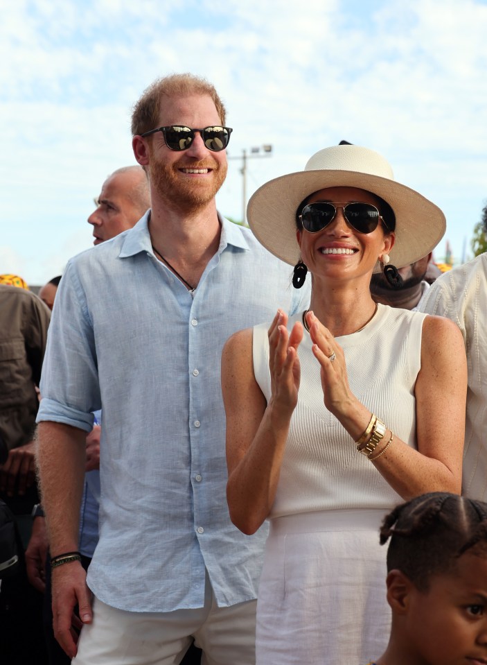 a man and a woman wearing sunglasses are smiling and clapping