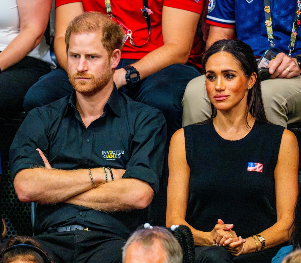 prince harry and meghan markle sit in the audience at the invictus games