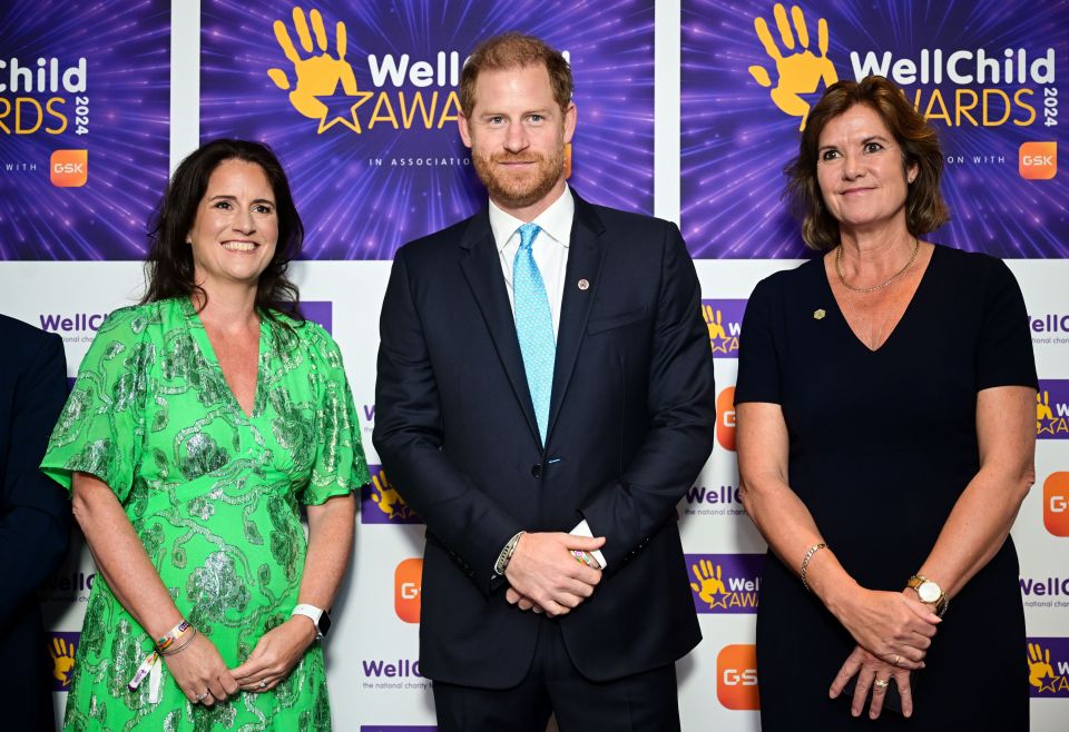 three people stand in front of a wall that says well child awards