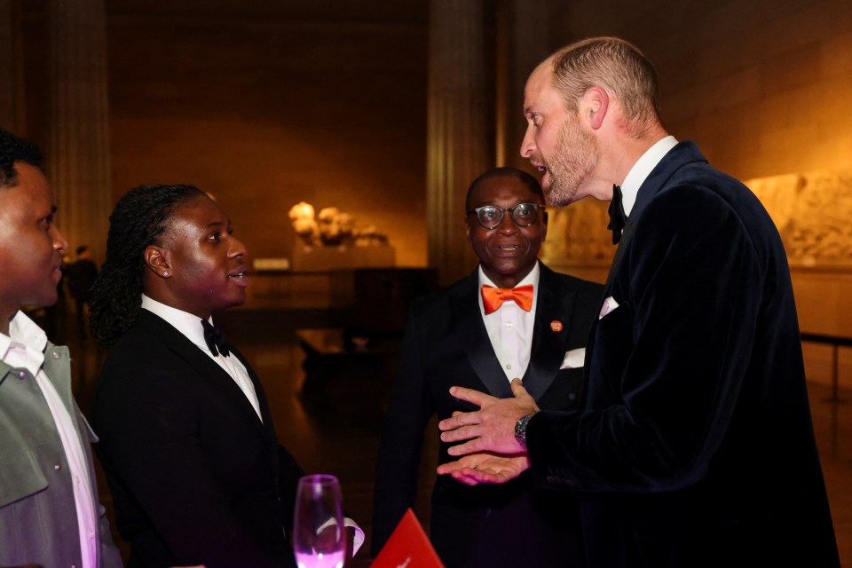 a man in a tuxedo is talking to two other men