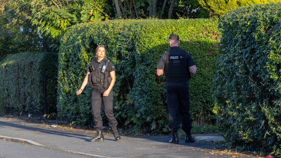 two police officers standing on the side of the road