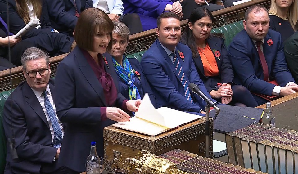 a group of people sitting in a room with a woman holding a piece of paper