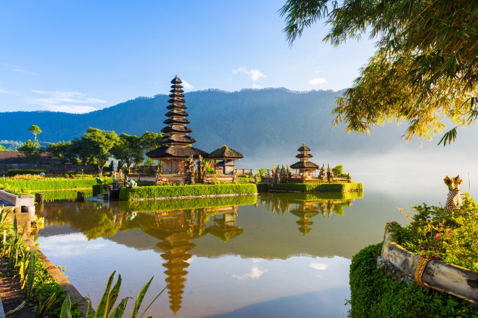 a temple sits on a small island in the middle of a lake