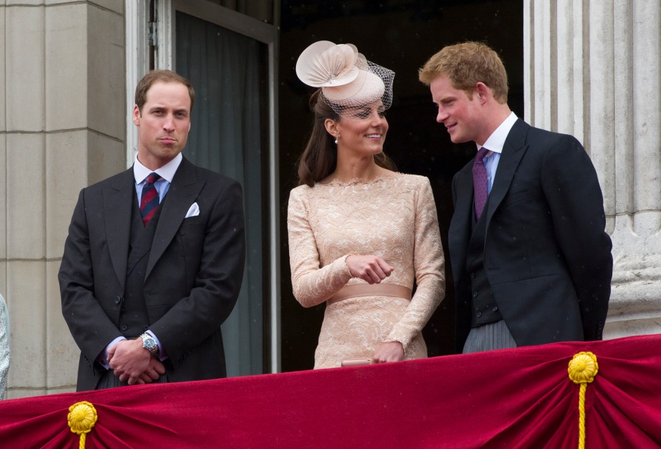 two men and a woman are standing on a balcony