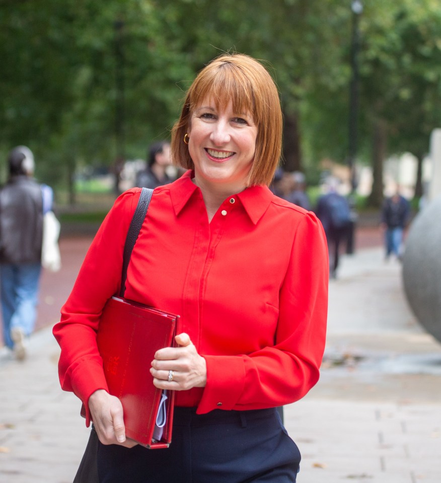 a woman in a red shirt is smiling and holding a red book