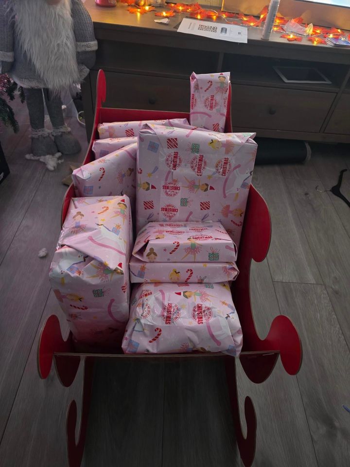 a sleigh full of christmas presents wrapped in pink paper