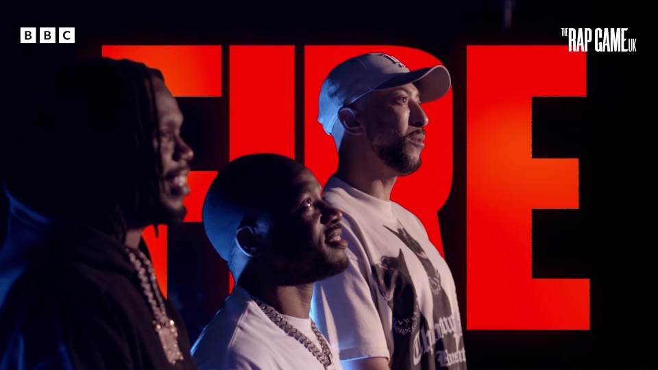 three men are standing in front of a bbc logo