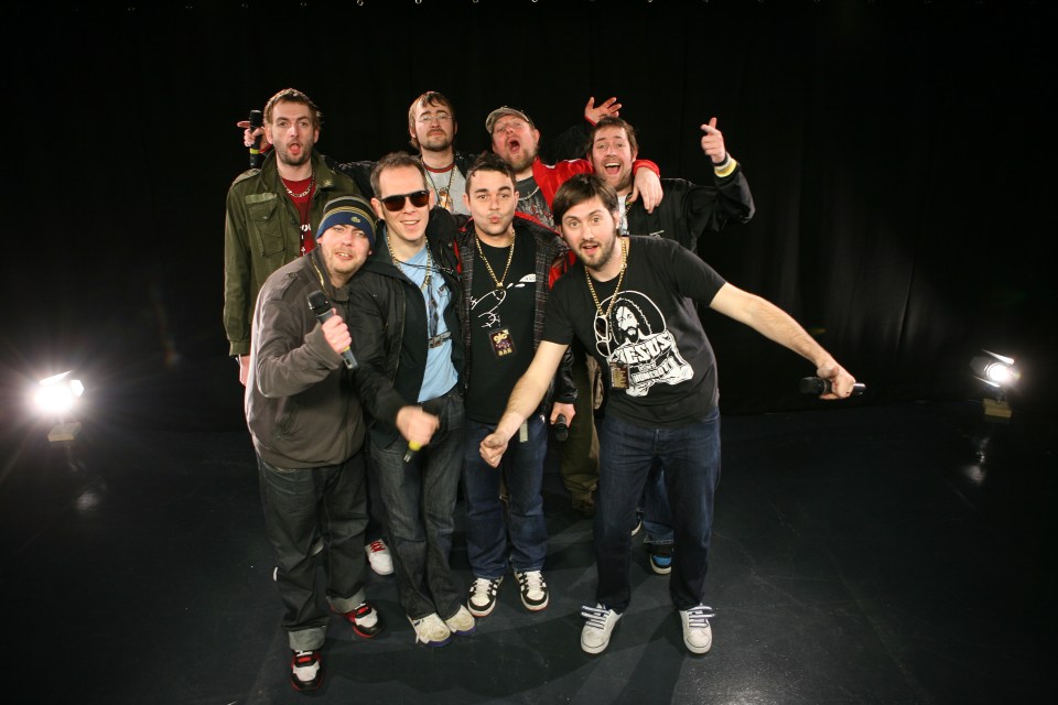 a group of men are posing for a picture and one of them is wearing a t-shirt with a skull on it