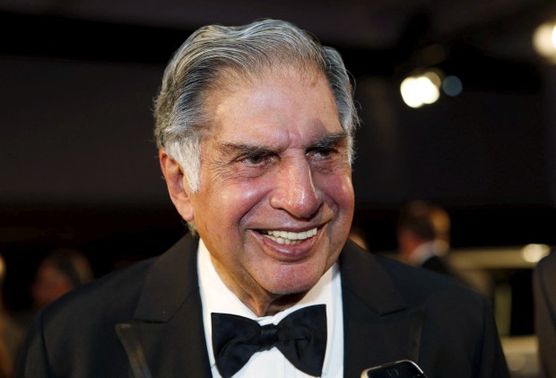 a man in a tuxedo and bow tie smiles for the camera