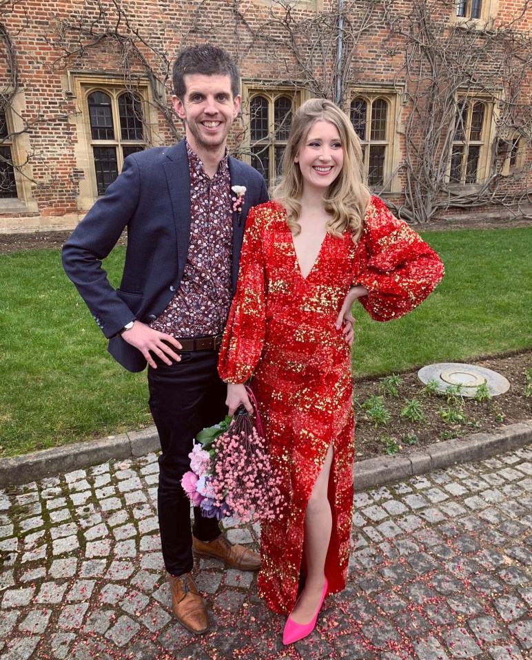 a woman in a red dress stands next to a man in a blue jacket