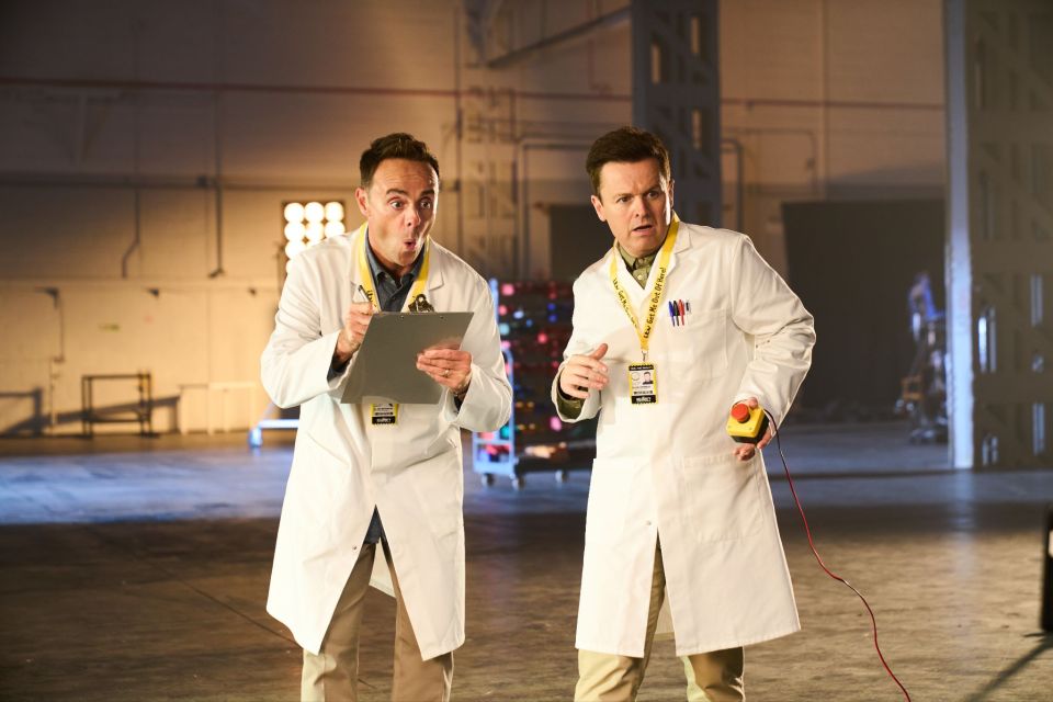 two men in lab coats holding a clipboard and a yellow lanyard that says ' emergency exit ' on it