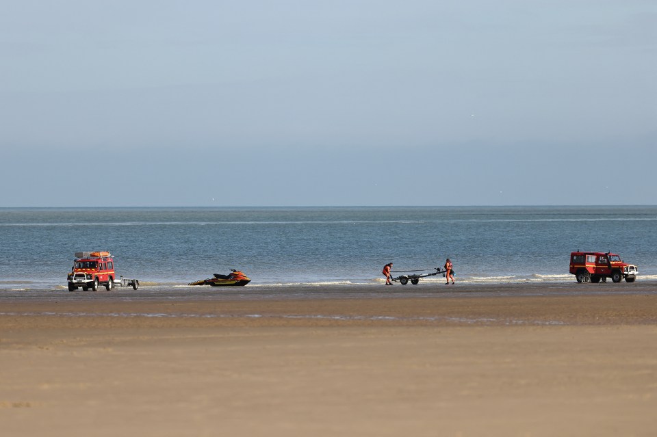 Rescue personnel prepare to pull a jet ski out of the water after the rescue operation