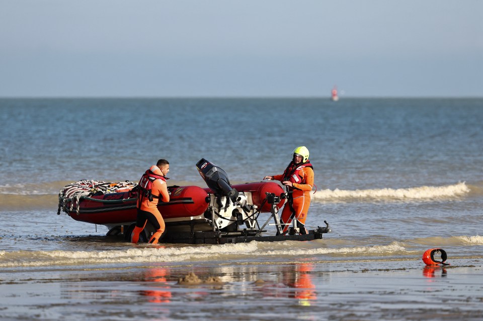 Rescue personnel pull their dinghy out of the water after attending the tragedy