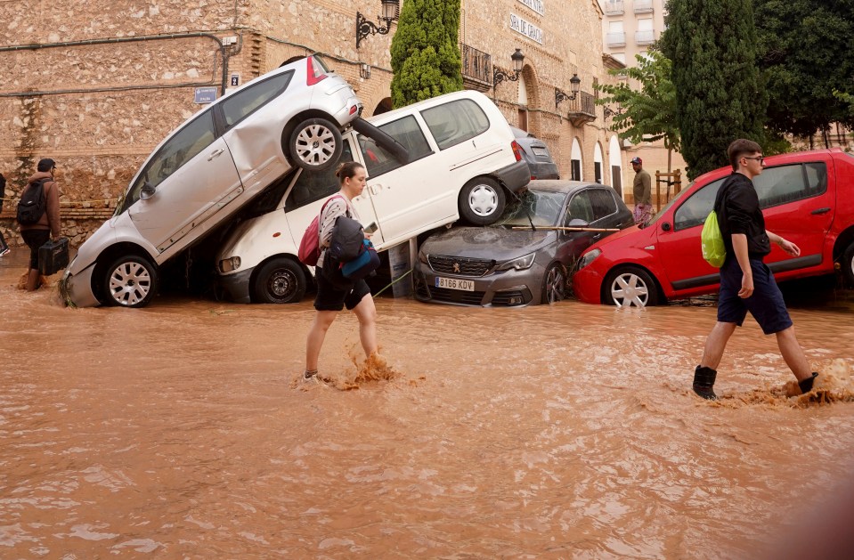 Locals walk through flooded streets in Valencia today