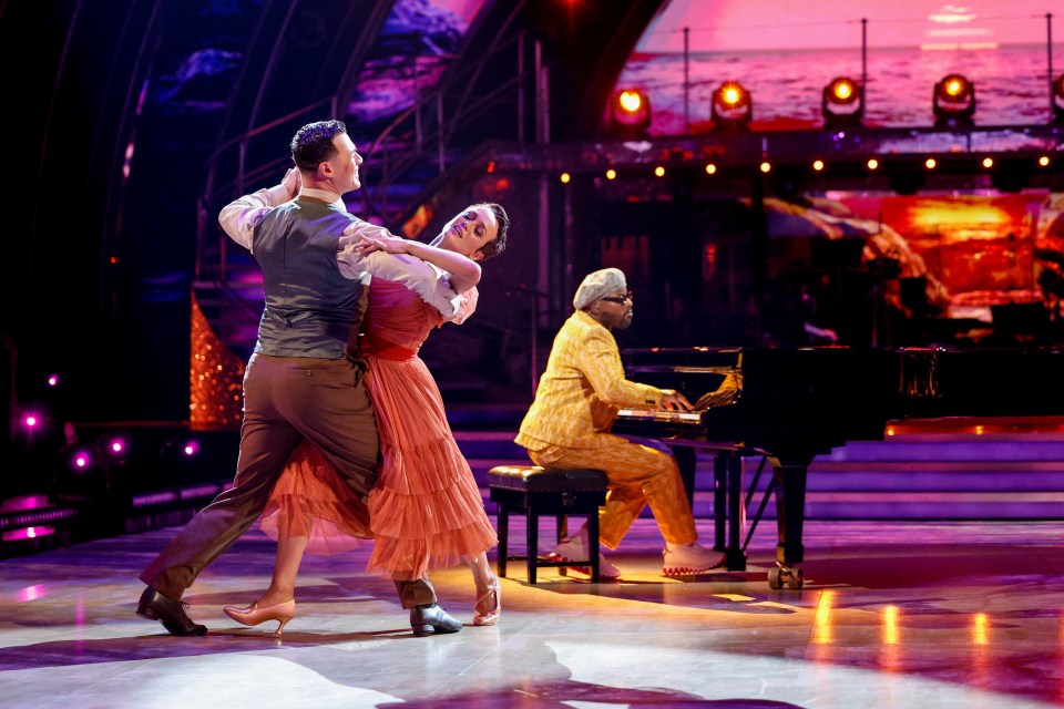 a man is playing a piano while a couple dances