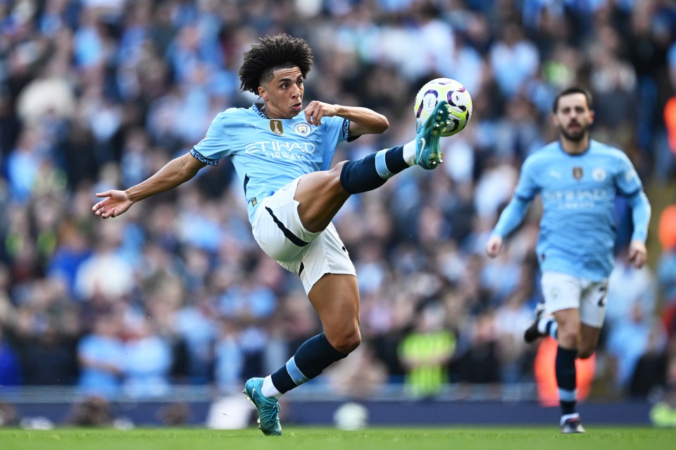 a soccer player wearing an etihad jersey kicking a ball