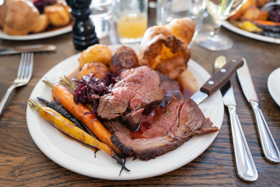 a white plate topped with roast beef carrots and potatoes