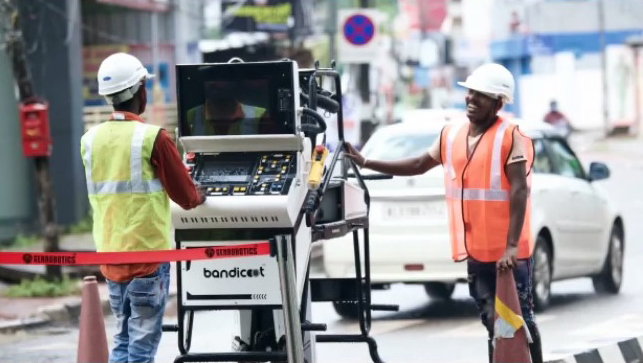 two men are working on a machine that says bandicent on it