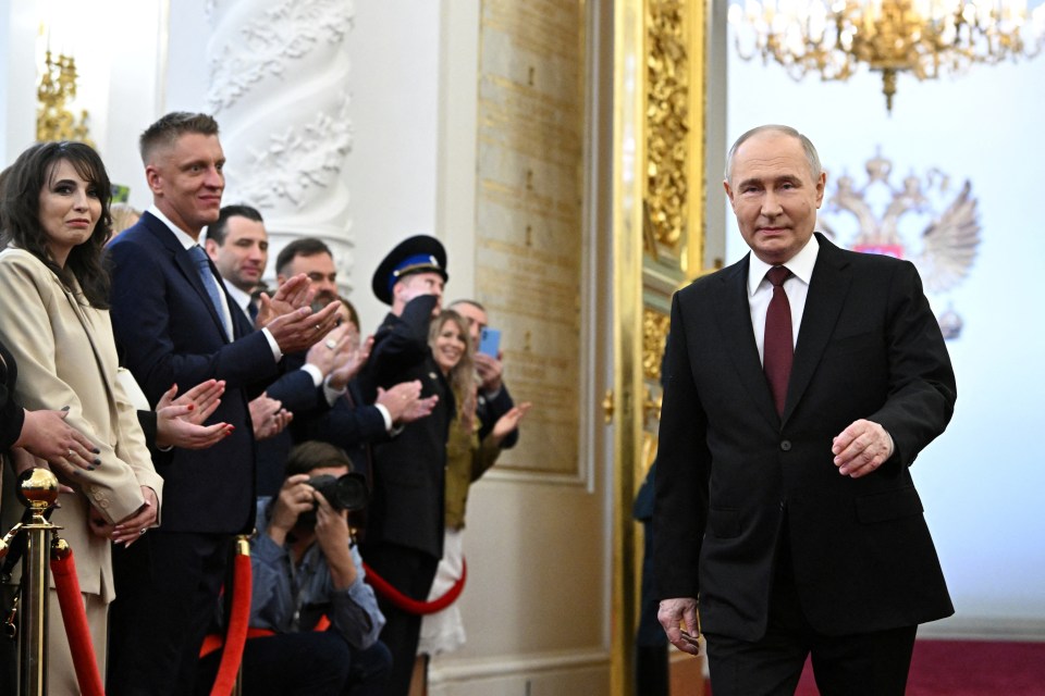 Putin walks into his inauguration ceremony at the Kremlin surrounded by his cronies