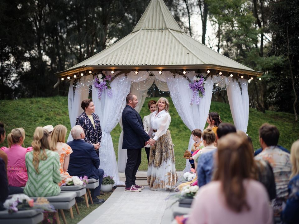 a bride and groom are getting married under a gazebo