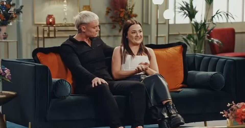 a man and a woman are sitting on a couch talking to each other