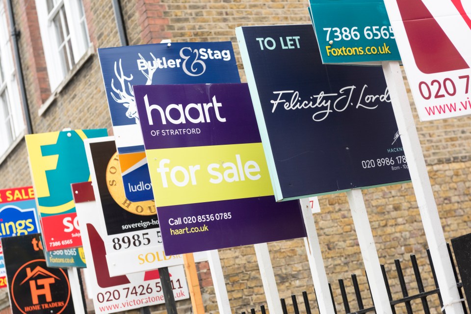 a man and a woman are looking at a display of houses for sale