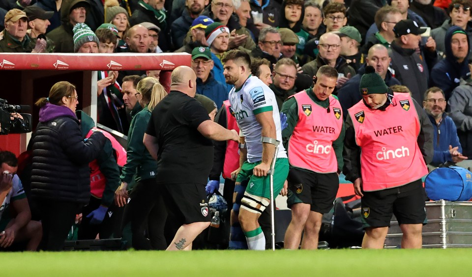 a man wearing a cinch shirt is being helped off the field