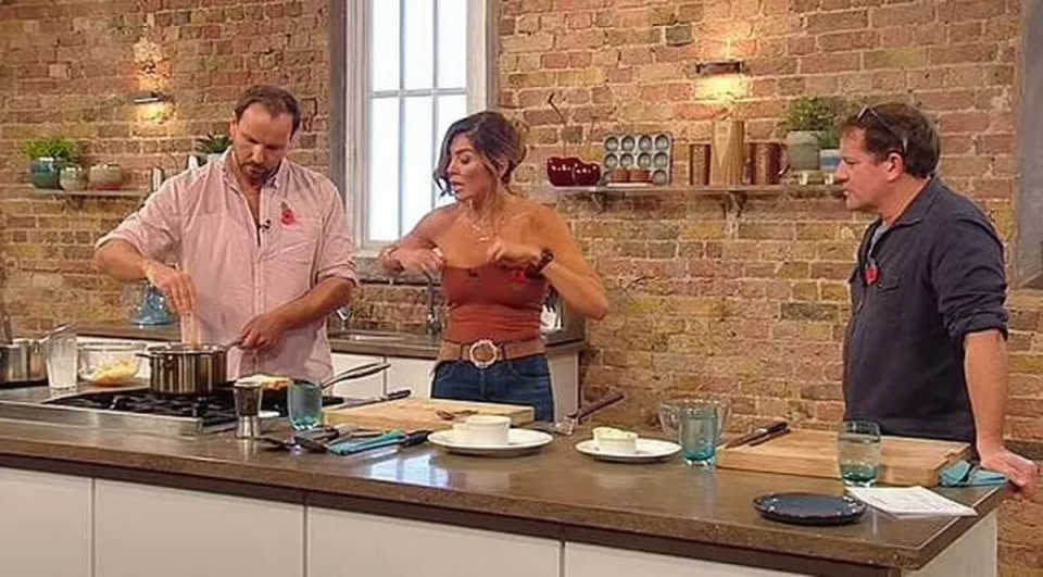 a man and a woman are standing in a kitchen preparing food .