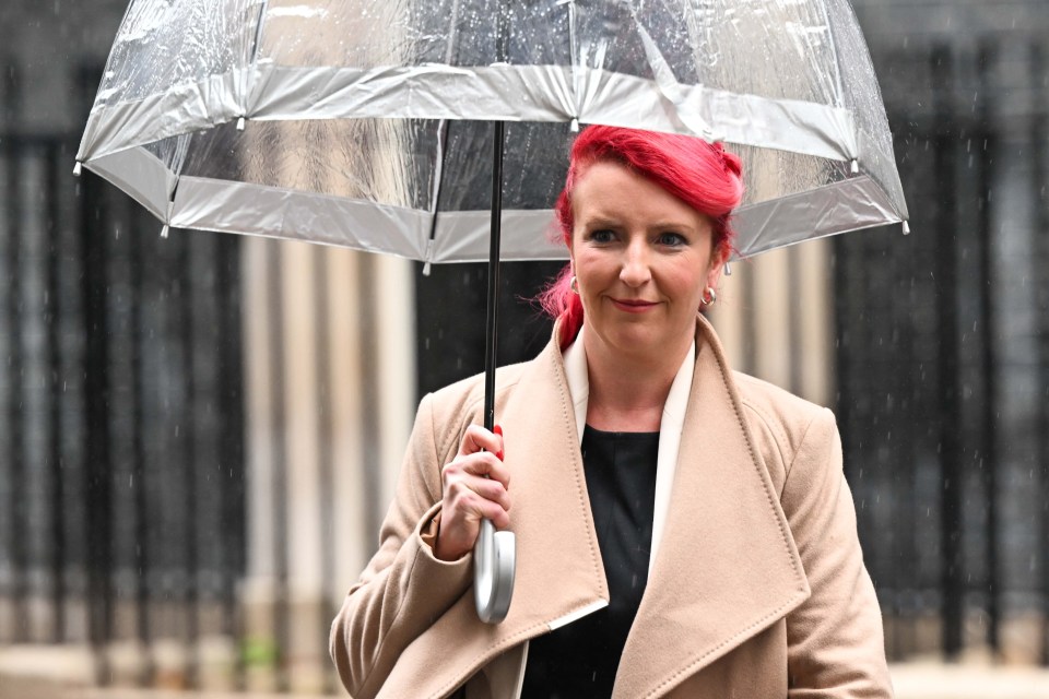 a woman with red hair is holding an umbrella in the rain