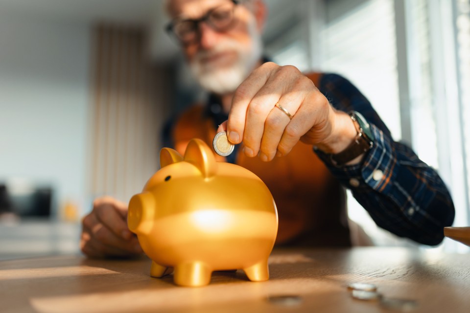 a man putting a coin into a piggy bank