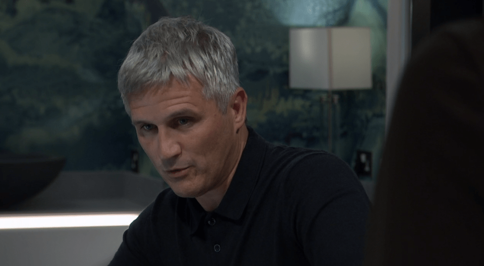 a man with gray hair is wearing a black shirt