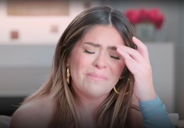 a woman crying with her hand on her forehead