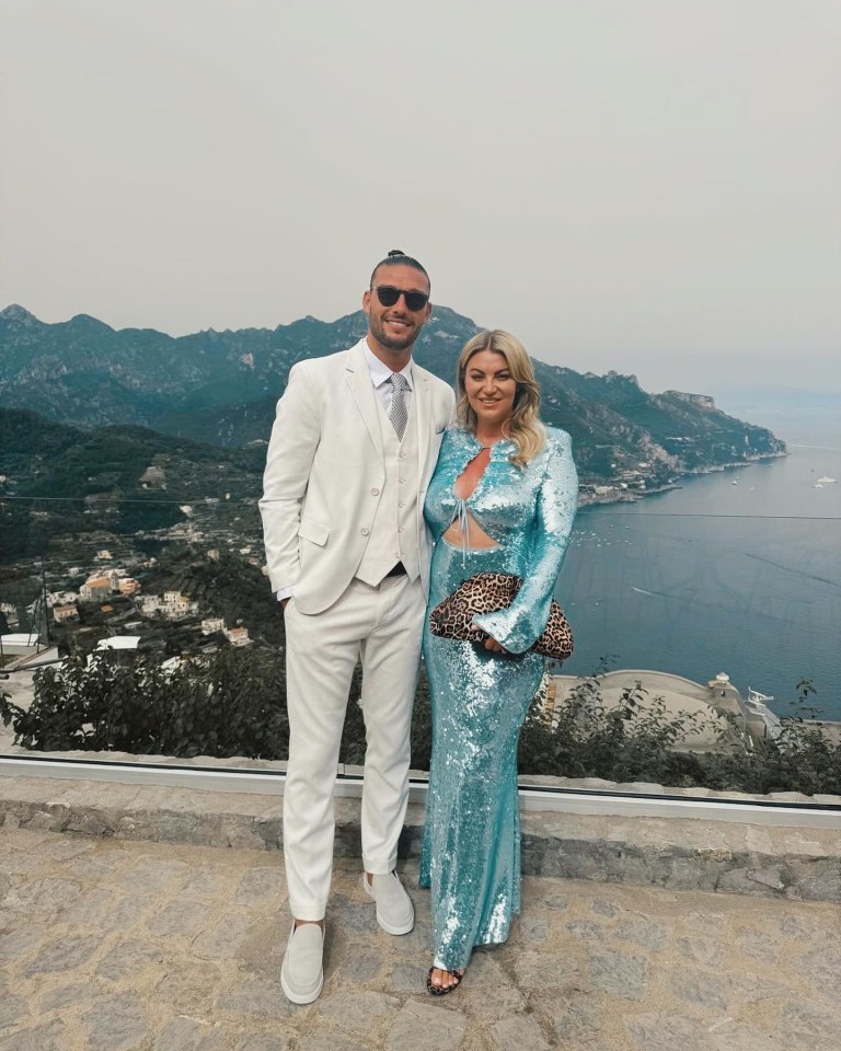 a man in a white suit stands next to a woman in a blue dress