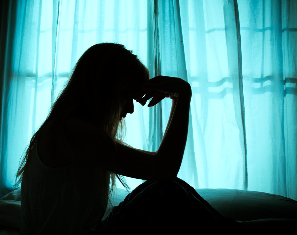 a silhouette of a woman sitting in front of a window