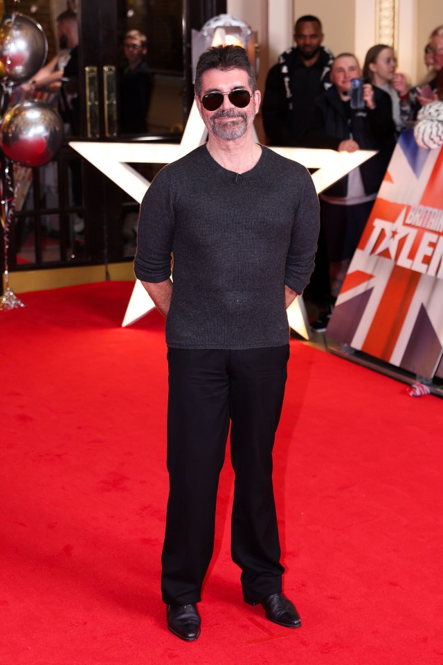 a man stands on a red carpet in front of a sign that says ' british talent '