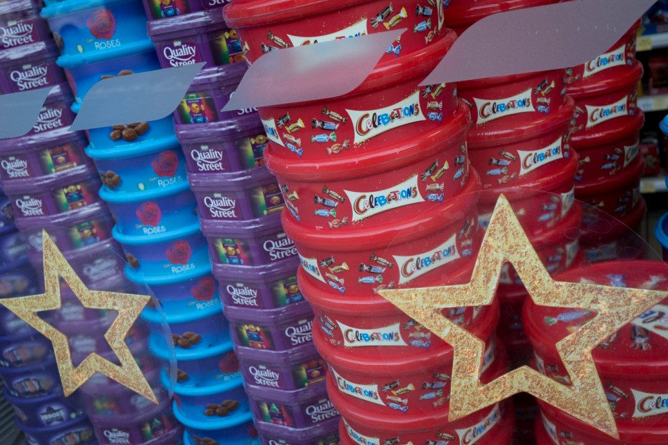 many containers of quality street celebrations are stacked on top of each other