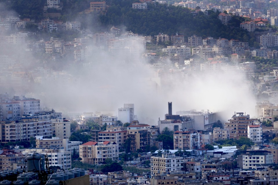 a city with smoke coming out of a building that says ' a ' on it