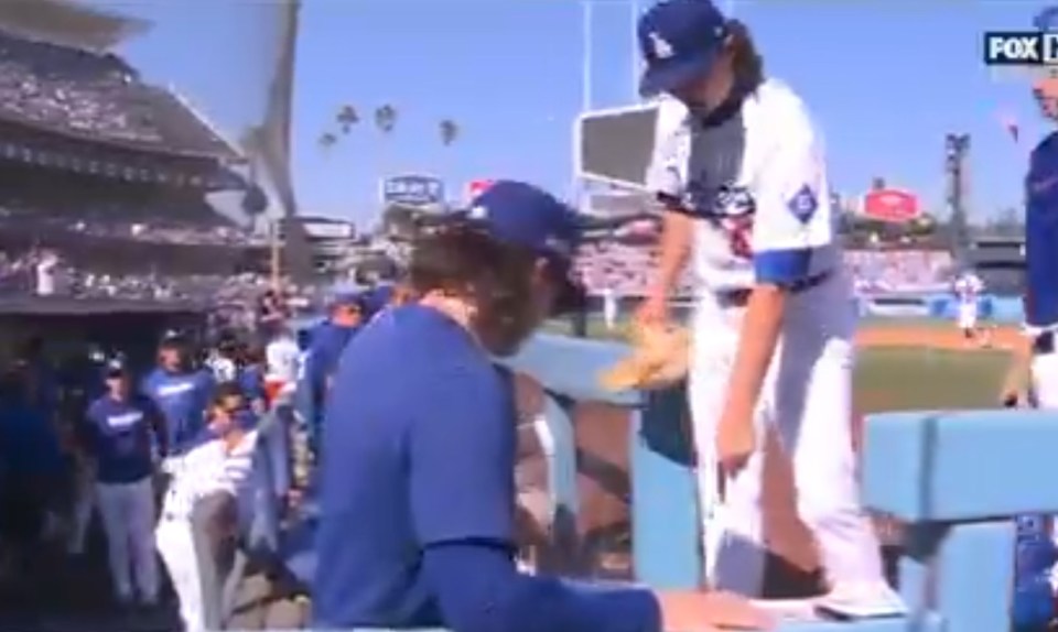 a baseball player is sitting on a bench at a baseball game .