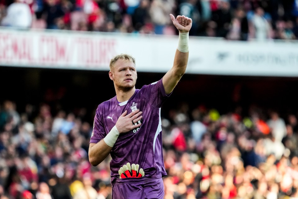 a soccer player wearing a purple puma jersey stands in front of a crowd