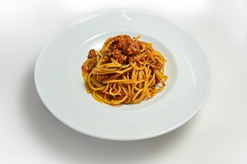 a white plate topped with spaghetti and meat sauce