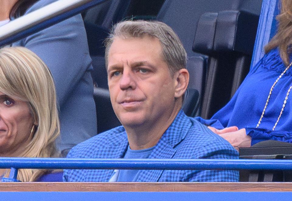 a man in a blue jacket sits in the stands