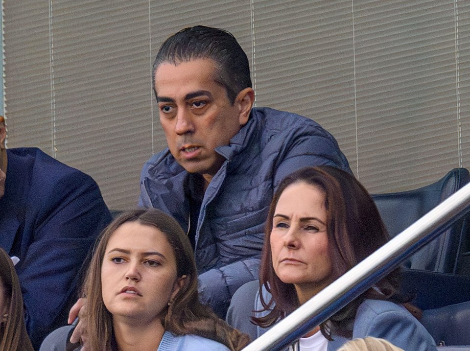 a man and a woman sit in a stadium watching a game