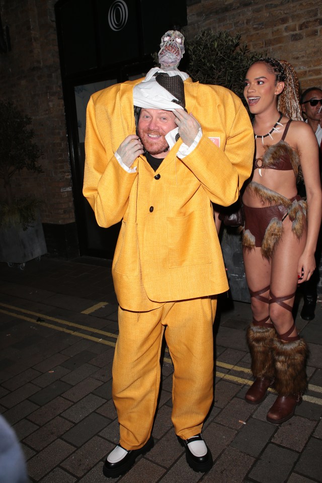 a man in a yellow suit has a monkey on his head