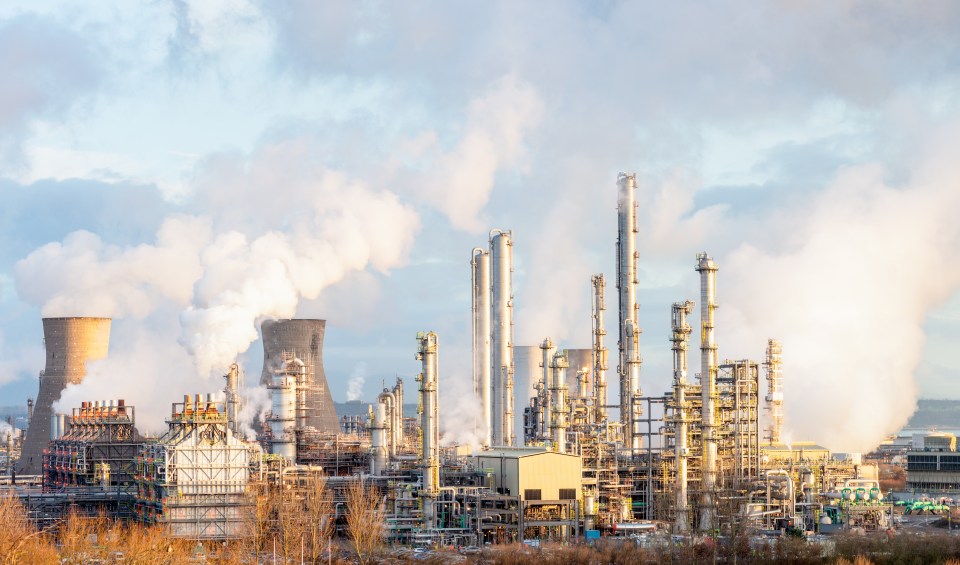 a factory with smoke coming out of the chimneys