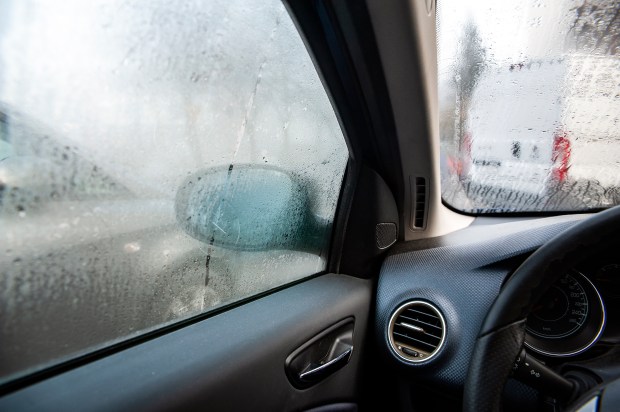 the inside of a car with a window that is covered in condensation