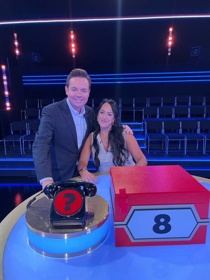 a man and a woman pose in front of a red box with the number 8 on it